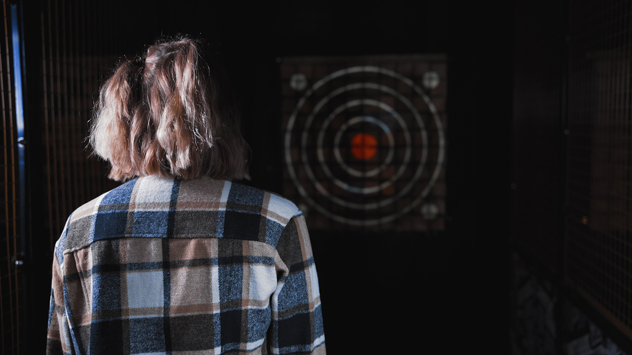 Thumbnail of a woman stood on an axe-throwing lane