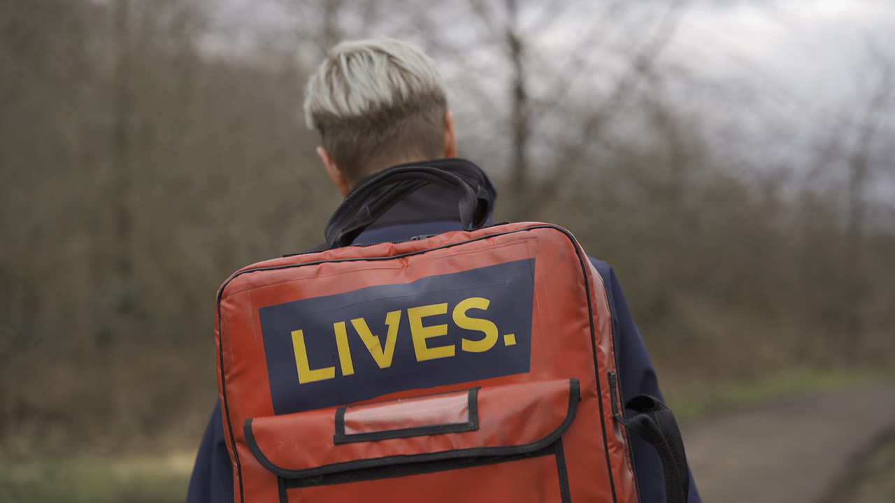 Thumbnail of the back of a LIVES first responder walking in the woods