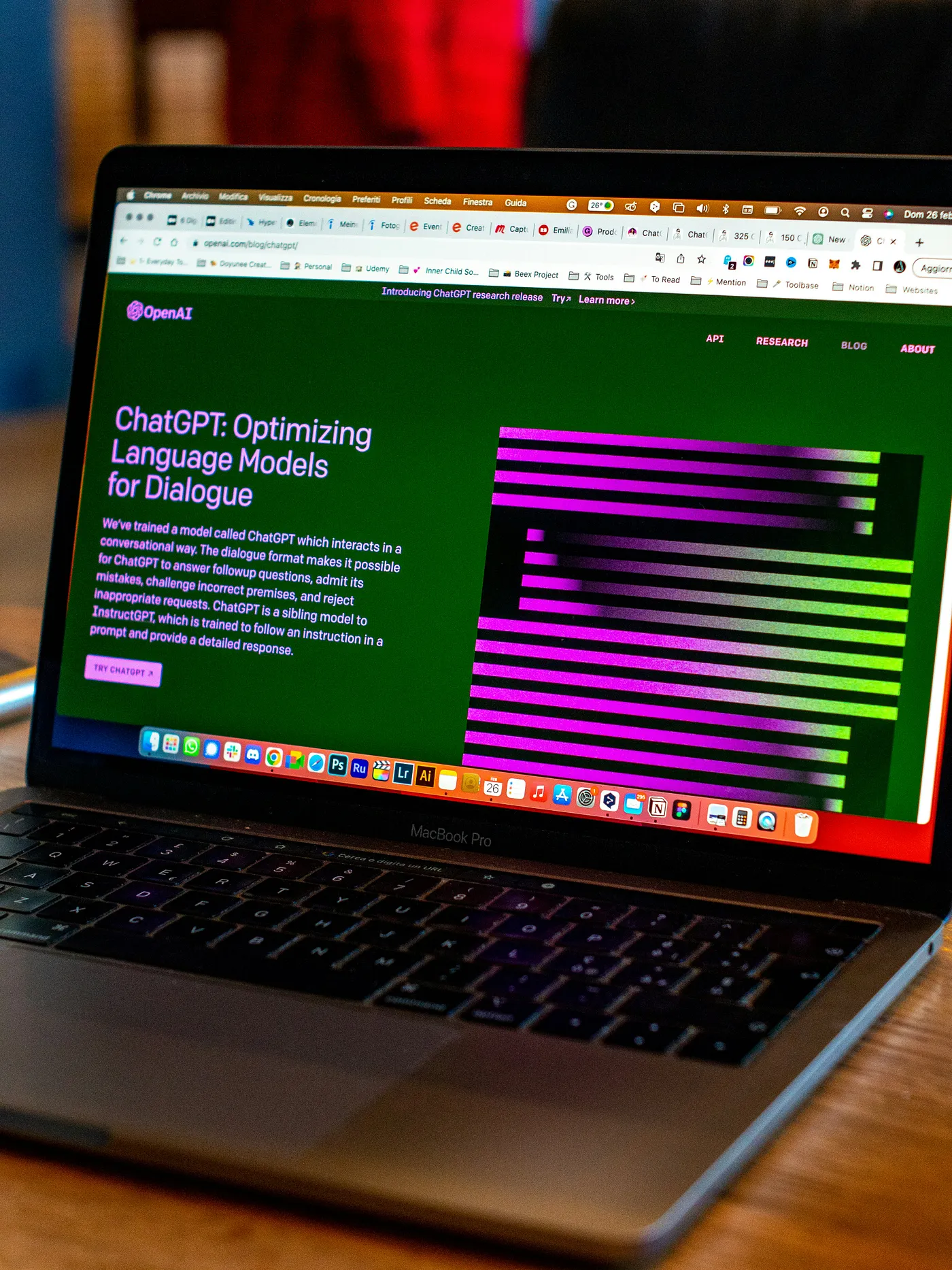 A MacBook Pro laptop on a wooden table displays a green webpage titled 